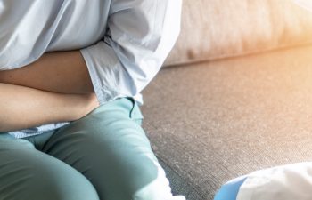 woman hugging her aching stomach