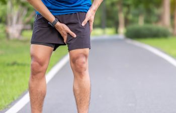 A male runner stopped by a sudden pain in a groin area.