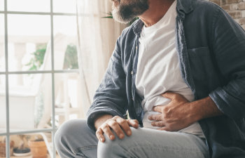 hand of mature guy holding abdomen suffering from ache